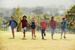 © Monkey Business - Six pre-teen friends running in a park, front view