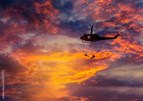 Fotografía silhouette soldiers in action rappelling climb down from helicopter with mili