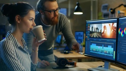 Poster - Female Video and Sound Editor Works With Her Male Colleague on a Project on Her Personal Computer with Two Displays. They Work in a Creative Loft Office.  Shot on RED EPIC-W 8K Helium Cinema Camera.