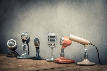 Poster - Retro old microphones for press conference or interview on the desk. Vintage style filtered photo