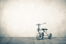 Old Retro Toy Bicycle With Three Wheels. Vintage Style Sepia Photo