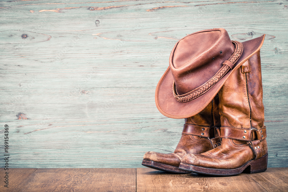 Obraz na płótnie Wild West retro leather cowboy hat and old boots. Vintage instagram style filtered photo w salonie
