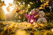 Kids Having Fun In Park, Throwing Up Leaves.