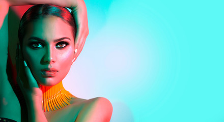 fashion model woman in colorful bright lights posing in studio. portrait of beautiful sexy girl with
