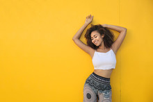 Girl Dancing In Front Of A Yellow Wall
