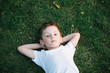 © ruslanshug - portrait of cute little boy lying on green grass