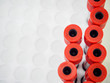 Close-up detail of multiple vacutainer tubes with red tops in a foam rack at a hospital. Healthcare and medical equipment concept.