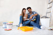© didesign - Young happy couple choosing colors for painting their home