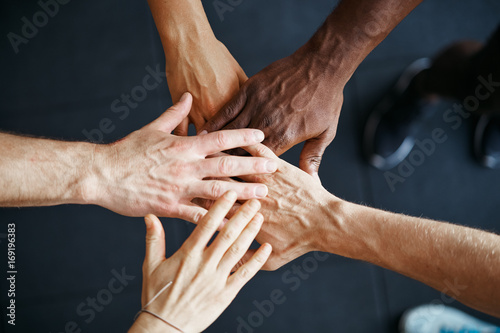 Fotografía Diverse people standing with their hands together in a gym