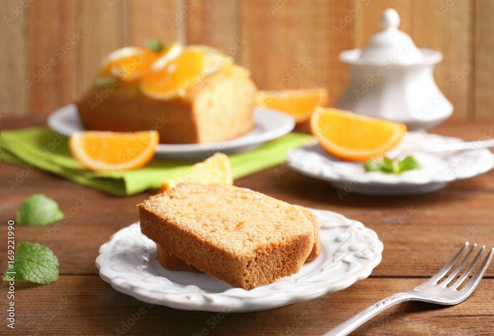 Plate with delicious sliced citrus cake on wooden table