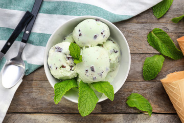 Wall Mural - Bowl with mint chocolate chip ice cream on wooden table