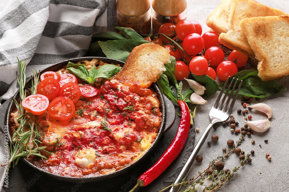 Frying pan with eggs in purgatory on table