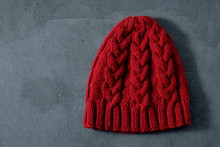 Red Knitted Cap With A Braid Pattern