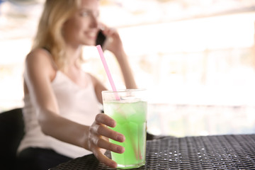 Poster - Beautiful young woman with glass of lemonade in cafe