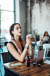 © teksomolika - Young woman sitting in coffee shop