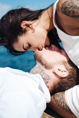 young couple are lying on the pier by the sea