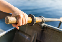 Female Hand On Row Boat Oar Closeup In Summer With Water