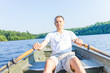 © Kristina Blokhin - Serious young man rowing boat on lake in Virginia during summer in white shirt
