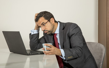 Wall Mural - arab man woking in his laptop in the kitchen