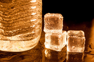 ice cubes with drinking water in golden light background.