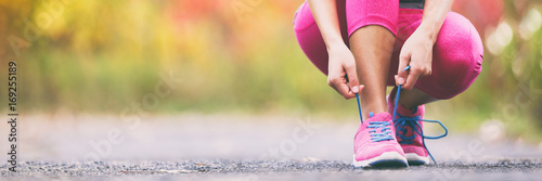 Cuadros en Lienzo Running shoes runner woman tying laces for autumn run in forest park panoramic banner copy space