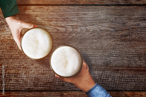 Cuadros en Lienzo Couple of Man and Woman holding a Glass of Beer to Celebrate in Restaurant or Ba