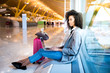 © DavidPrado - woman working with laptop at the airport waiting at the window