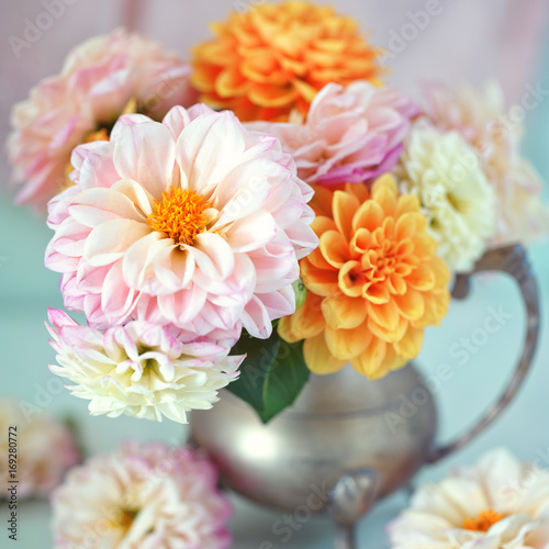 Fotografía Beautiful bouquet of a yellow and pink dahlias on a light green background