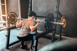 © joyfotoliakid - Muscular Man built athlete working out in gym and weightlifting machine and lifting barbell