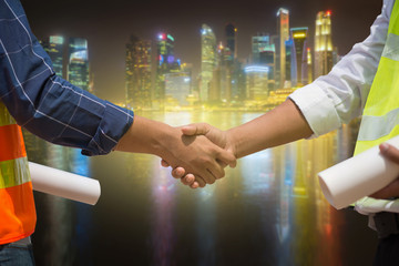 Wall Mural - Conclusion of the contract, Partnership, Gesture and people concept, Close up of builders hands greeting each other with handshake on city background