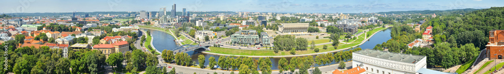 Beautiful and bright panoramic view from top of the hill of Gediminas' Tower on Vilnia river and old Vilnius center, Vilnius Lithuania.  Panorama of Vilnius city. - obrazy, fototapety, plakaty 