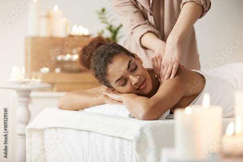 Fotografía Tender african girl smiling enjoying massage with closed eyes in spa resort