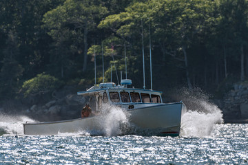 Lobster boat comes home from a rough day at sea in early autumn in South Bristol, Maine, United States