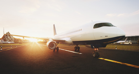 Wall Mural - White commercial airplane standing on the airport runway at sunset. Front view of passenger airplane is taking off. Airplane concept 3D illustration.