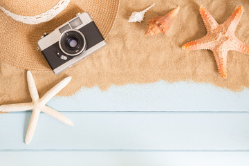 film camera and sea shells on sand on blue background,summer concept top view