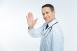 © Viacheslav Yakobchuk - Positive minded mature doctor waving hello over background