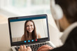 © fizkes - Smiling girl on videocall with guy, making video call to close foreign friend, talking by web camera, using virtual chat app online, long distance relationships, focus on screen, close up rear view