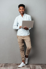 Poster - Full length portrait of a young smiling african man