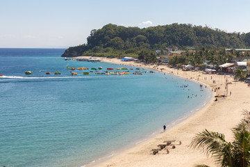 Seascape of beach with transparent sea, blue sky, palms and boats.Taken Sabang, popular tourist and diving spot.    