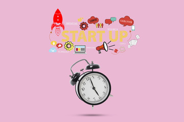 black alarm clock with startup concept idea business isolated on pink background.