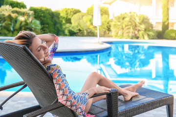 Sticker - Beautiful young woman relaxing on sun lounger near swimming pool