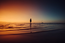 Woman Walking On The Sea At Magic Sunset