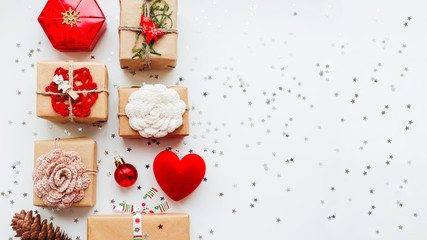 Wall Mural - Christmas and New Year background with presents and decorations - red heart, craft paper, handmade crocheted flowers and symbols of holiday.