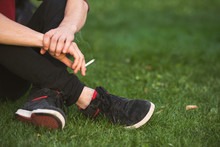 Man Smoking A Cigarette Outdoor Sitting On The Grass