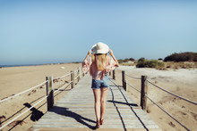 Woman With Hat Walking On The Wooden Bridge