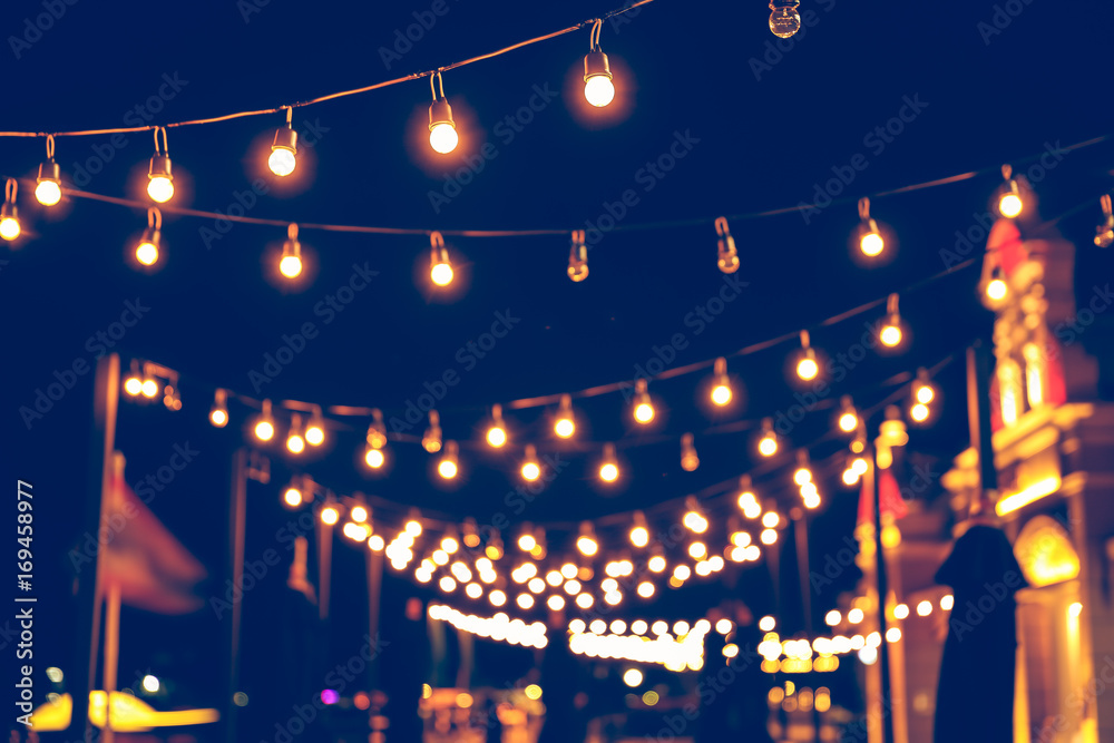 Selective focus on Light bulbs and bokeh background with effect filter, Abstract background, vintage tone at night light festival.