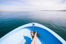 Feet Of A Person On A Boat Sailing Through Scenic View Of The Sea