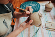 © Sergey Filimonov/Stocksy - Woman potter making pattern on the ceramic cup in her workshop