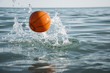 orange water polo ball on blue water background