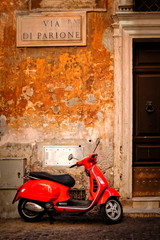 Canvas Print - Typical scene with a red scooter on a narrow central Rome street